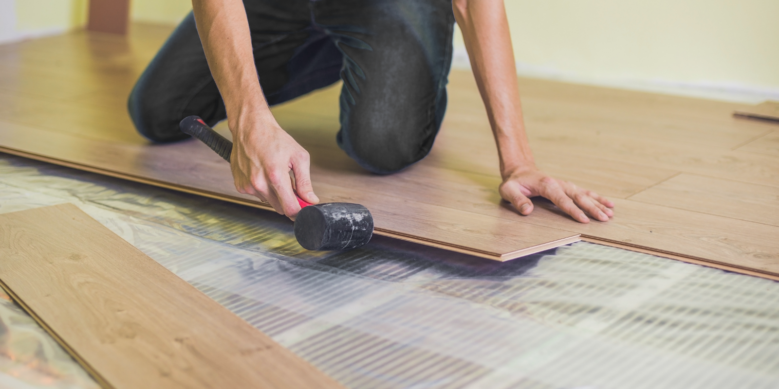 Contractor installing radiant floor heating mats